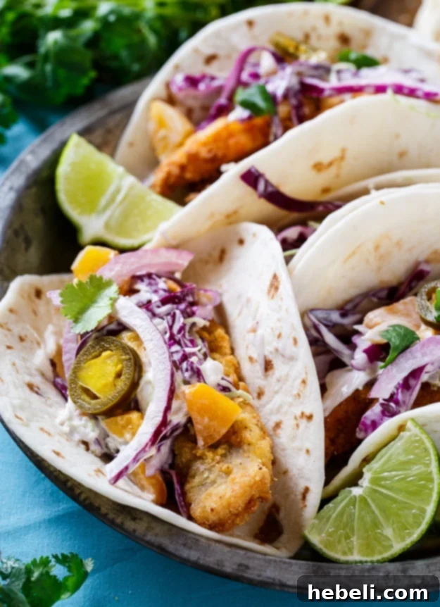 Southern Catfish Tacos and Jalapeno Peach Slaw, a close-up showing the vibrant colors and textures.