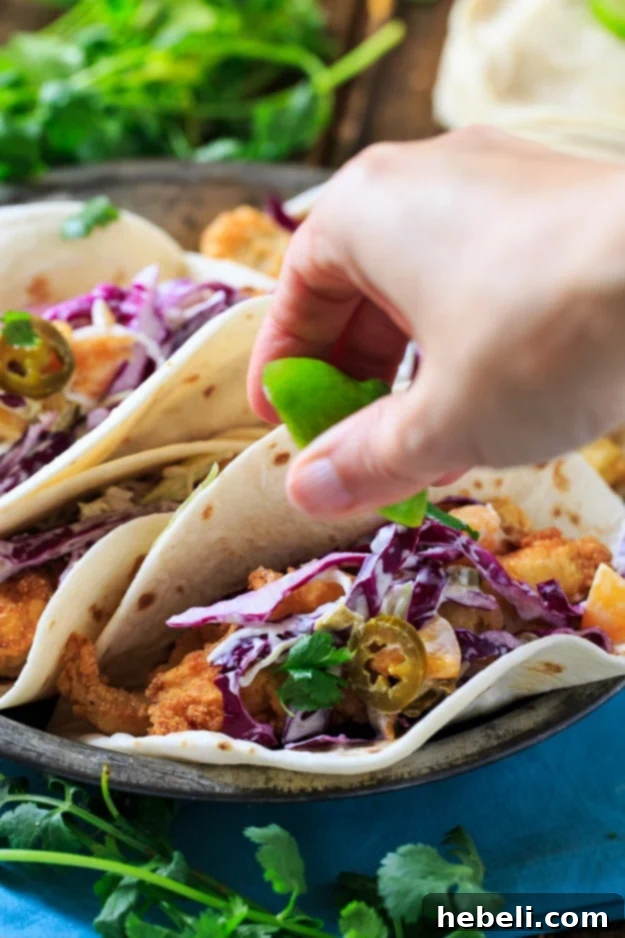 Southern Catfish Tacos with Jalapeno Peach Slaw, showcasing a fully assembled taco ready to be enjoyed.