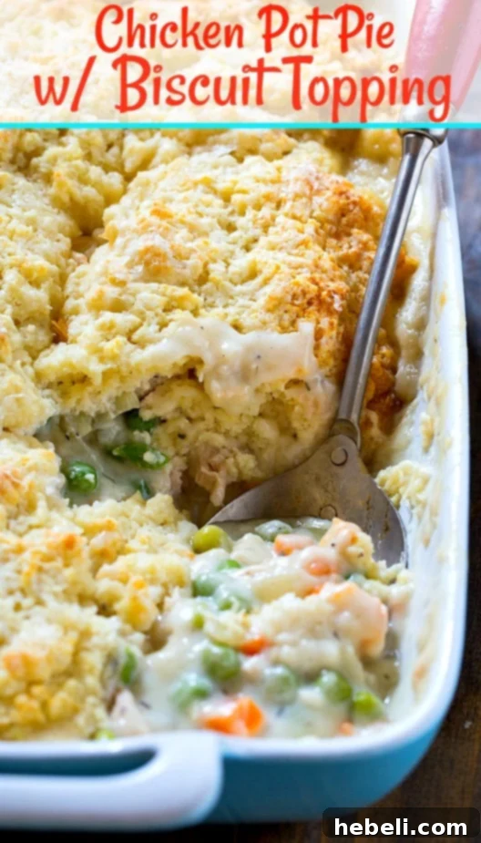 A close-up shot of the flaky, golden biscuit topping of a chicken pot pie, with steam rising.