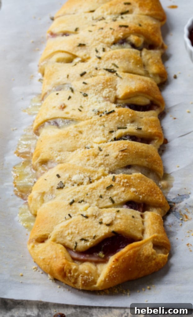 Festive Turkey Cranberry Brie Crescent Braid 4 Multiple Turkey, Cranberry, and Brie Crescent Braids on a cooling rack, showcasing their golden-brown perfection
