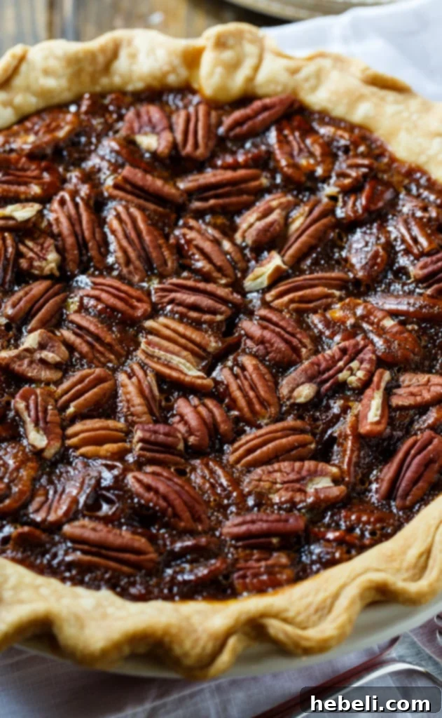 Sweet and Salty Pecan Perfection 4 A top-down view of a freshly baked salted caramel pecan pie, highlighting its intricate pecan topping and glossy caramel finish.