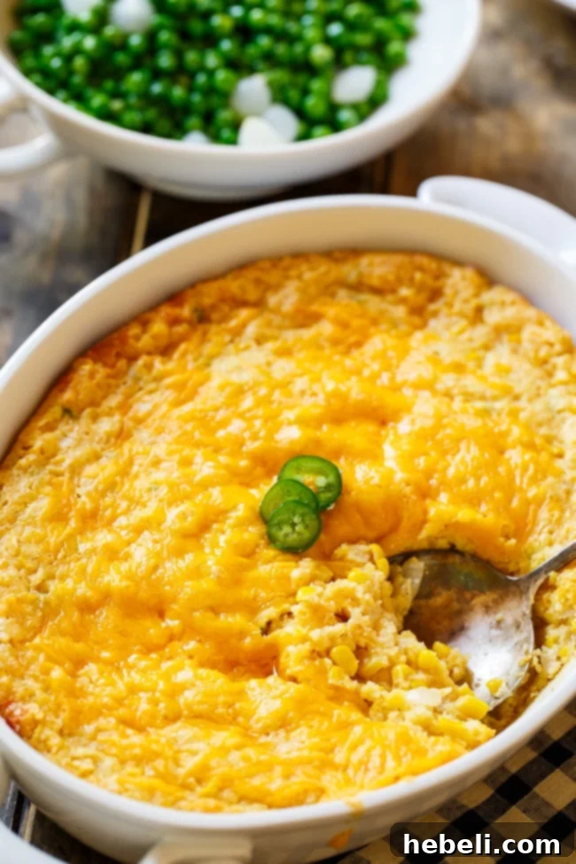 Jalapeno Popper Corn Casserole 5 Cheesy Jalapeno Corn Casserole being scooped from a baking dish