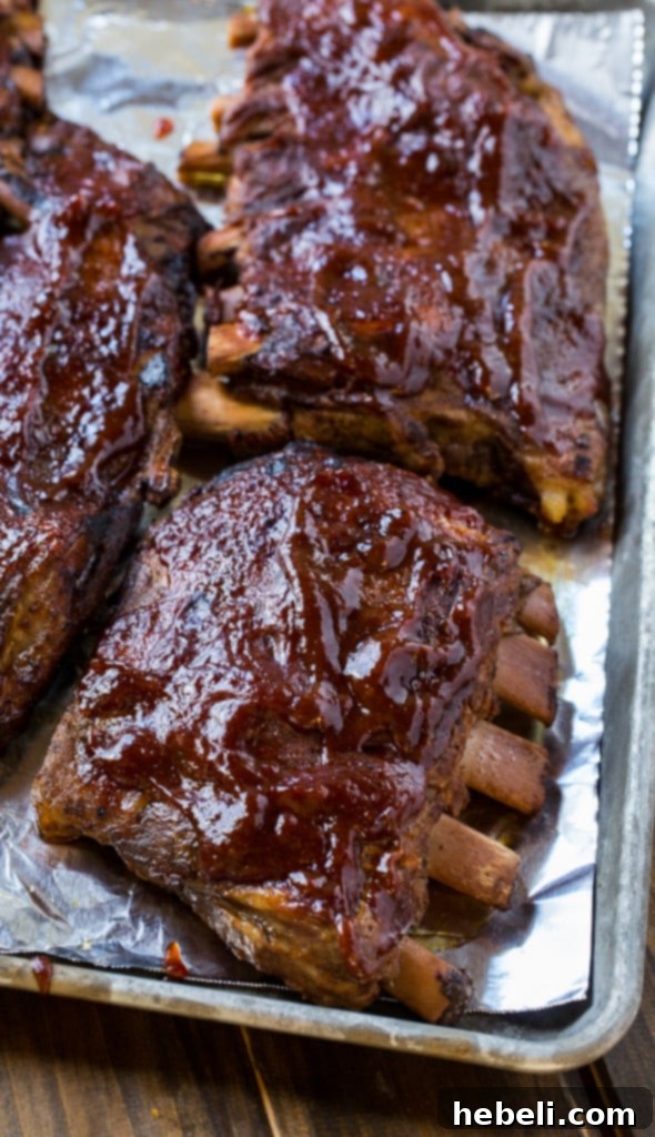 A close-up of delicious slow cooker ribs glistening with homemade BBQ sauce, ready to be broiled for a crispy finish