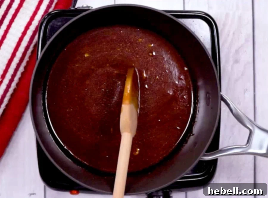 Homemade BBQ sauce simmering gently in a saucepan, filling the kitchen with its sweet and tangy aroma