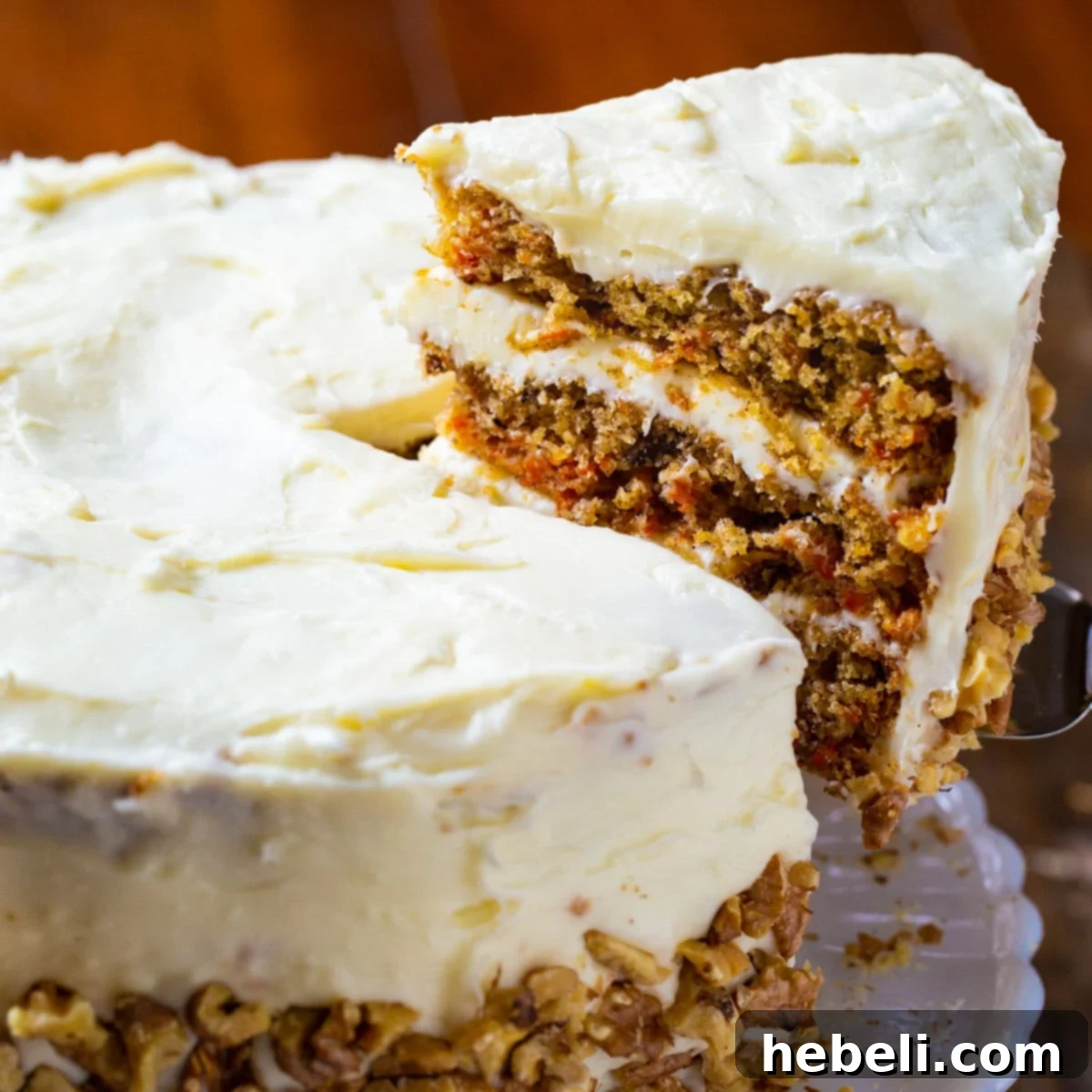 Mama Dip's Legendary Carrot Cake 2 A delectable slice of Mama Dip's Carrot Cake being lifted, showcasing its moist layers and rich cream cheese frosting.