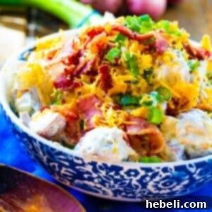 An appetizing image of Loaded Ranch Potato Salad in a serving bowl, showcasing its rich texture and generous toppings of bacon and green onions, perfect for a recipe card.