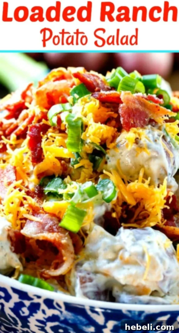 A charming blue and white patterned bowl filled with creamy Loaded Ranch Potato Salad, presented beautifully on a rustic table.