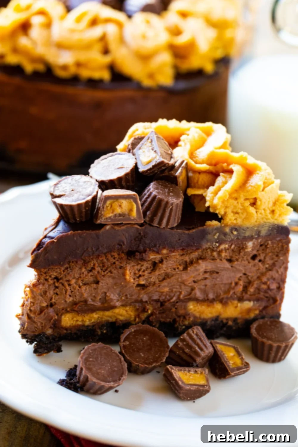 Decadent Chocolate Peanut Butter Cup Cheesecake 4 A perfect slice of Chocolate Peanut Butter Cheesecake, revealing its layers of Oreo crust, peanut butter cups, and chocolate filling.