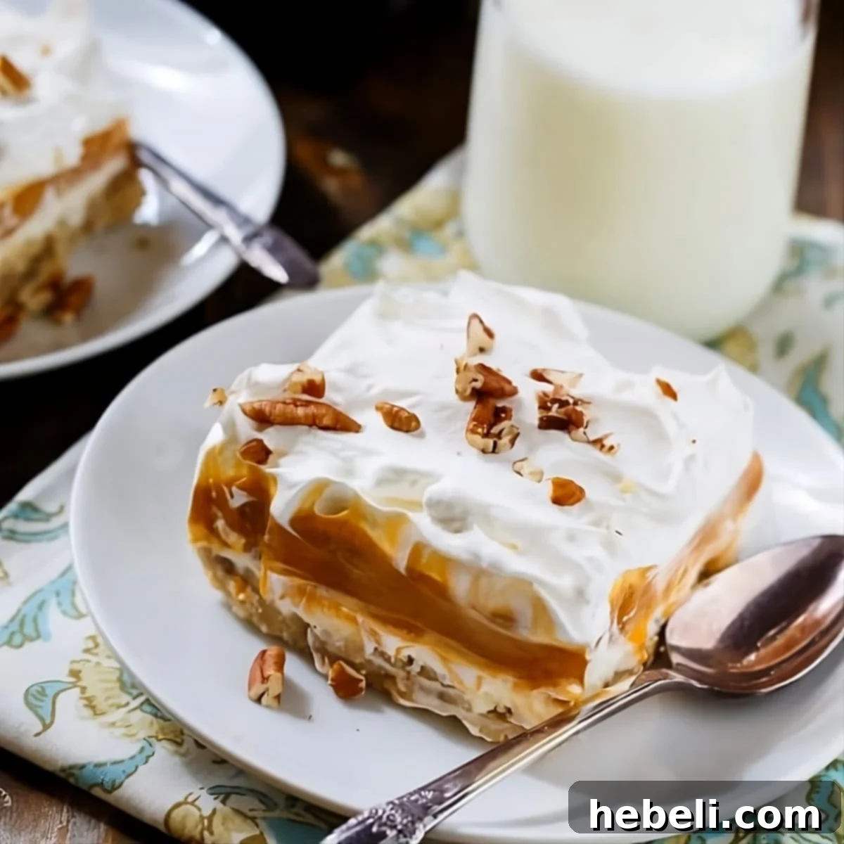 A generous slice of creamy Butterscotch Lush on a plate, showcasing its distinct layers and golden hue.