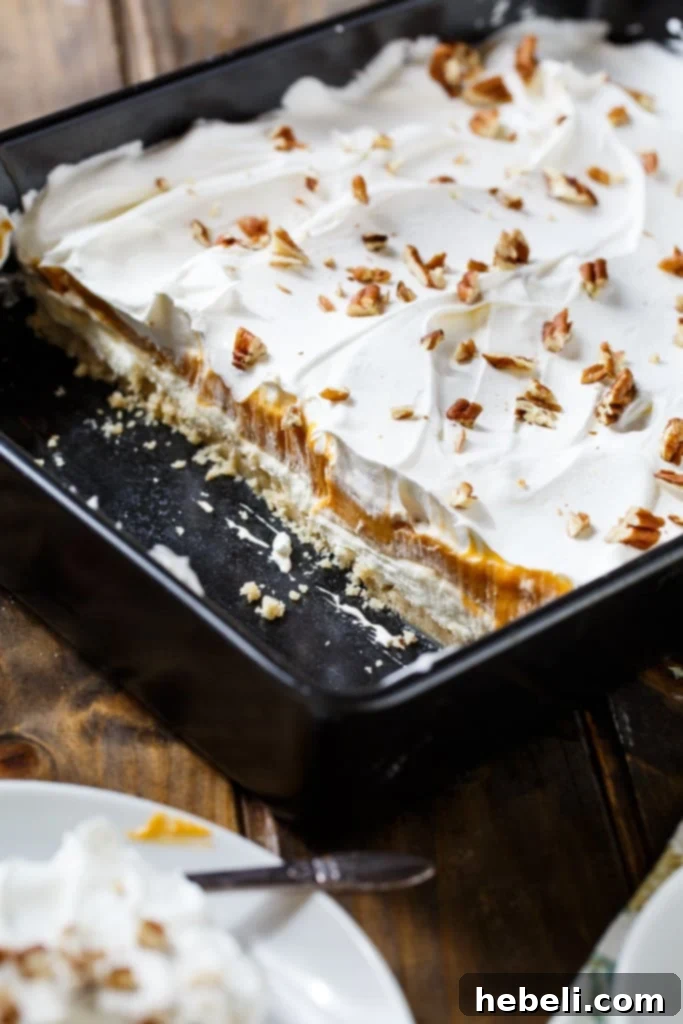 A close-up of a generous slice of Butterscotch Lush, highlighting the interplay of the crispy crust and creamy layers.