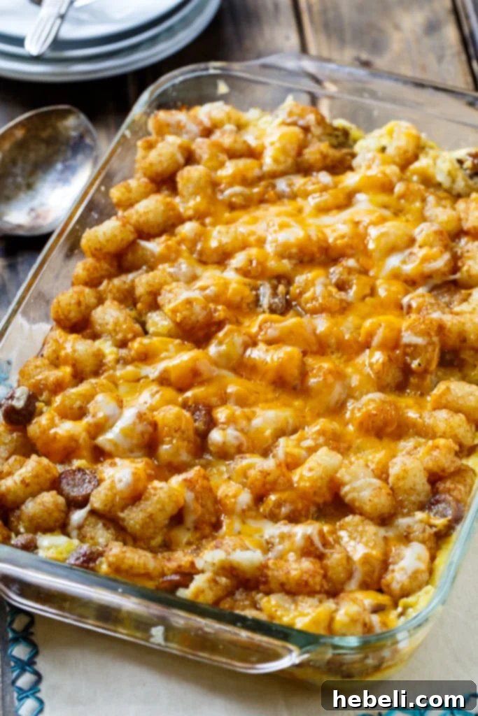 Close-up shot of Breakfast Tater Tot Casserole showing bubbling cheese and crispy tater tots.