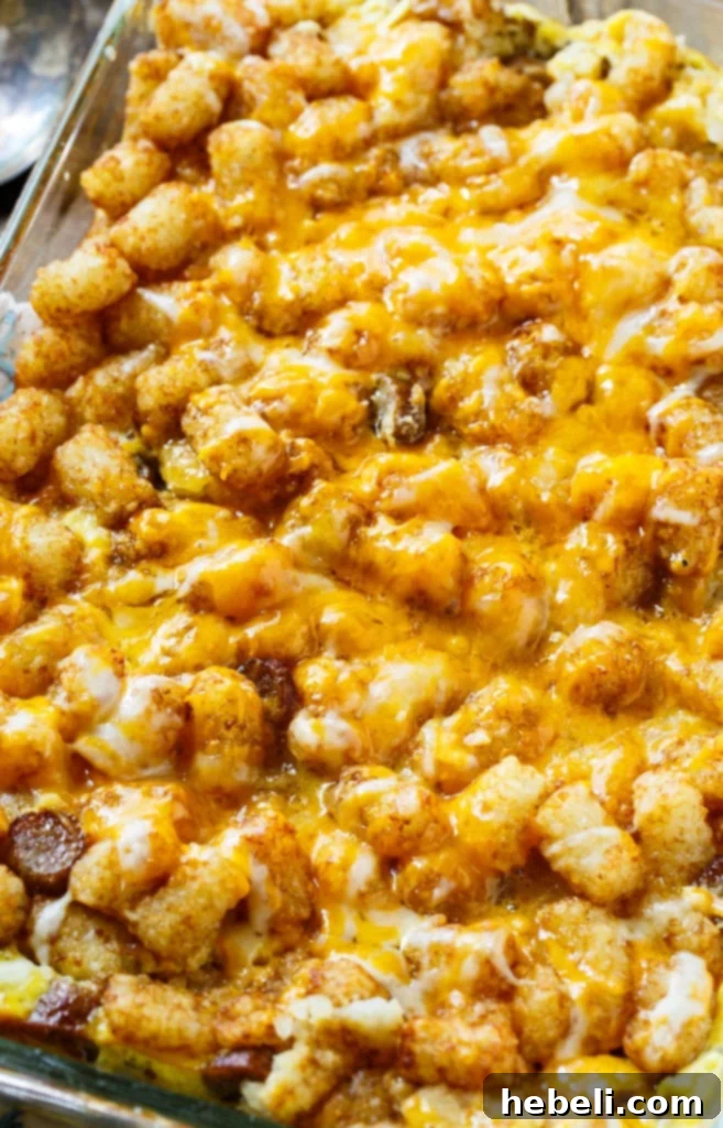 A serving of Breakfast Tater Tot Casserole showing its layers of eggs, sausage, and crispy tater tots.