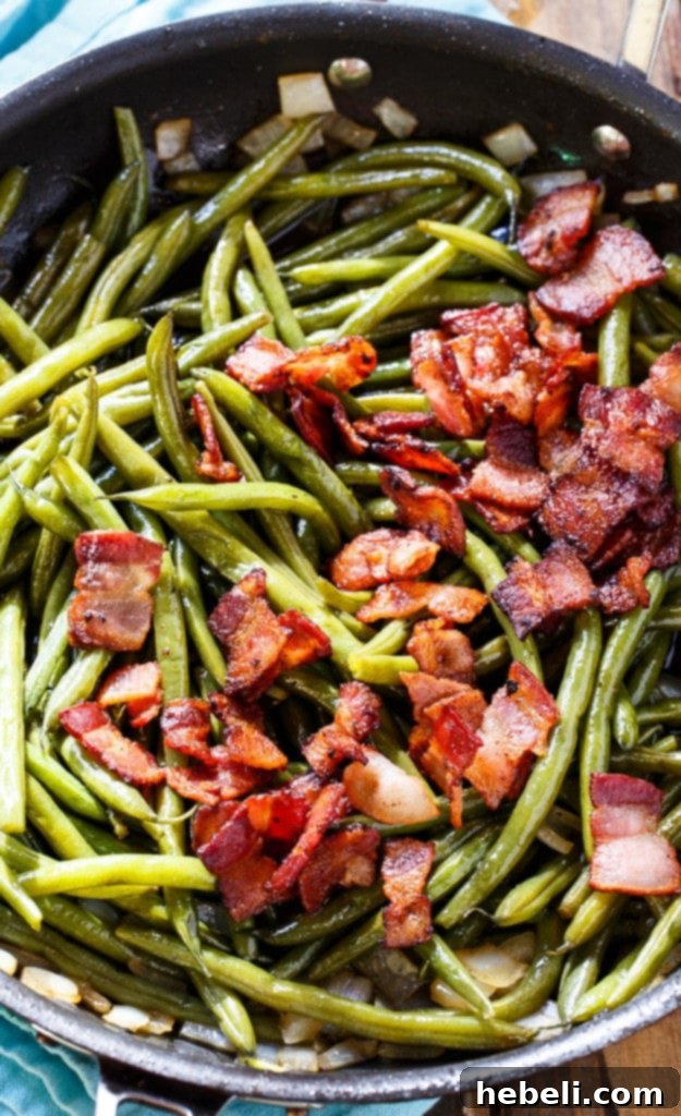 Close-up of Sweet and Sour Green Beans with generous amounts of crispy bacon and caramelized onions.