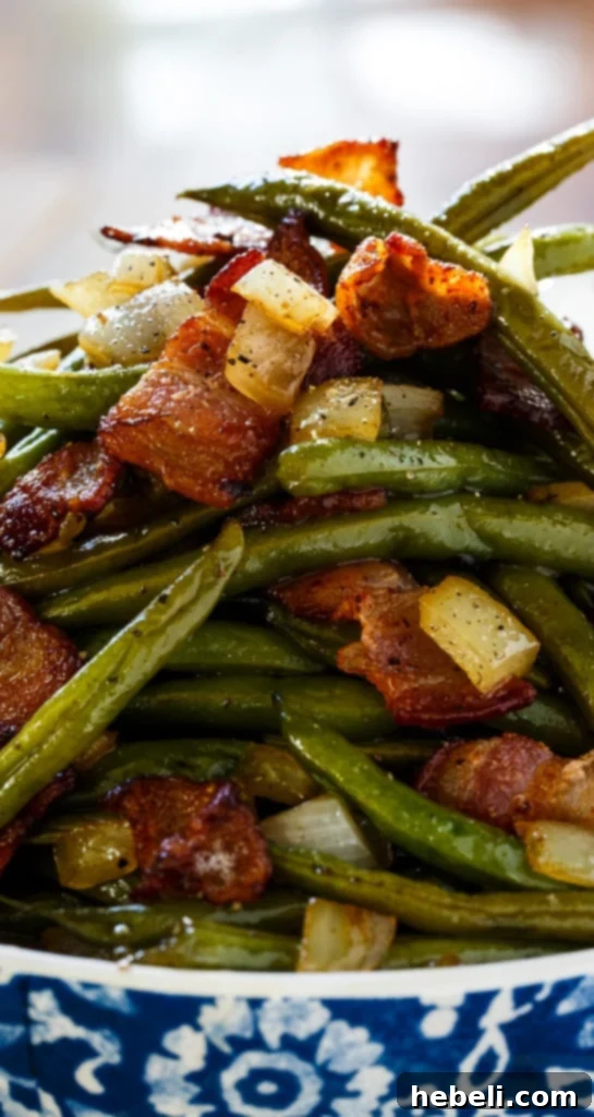 A close-up shot of the finished Sweet and Sour Green Beans, highlighting the glistening sauce, bacon, and onions.