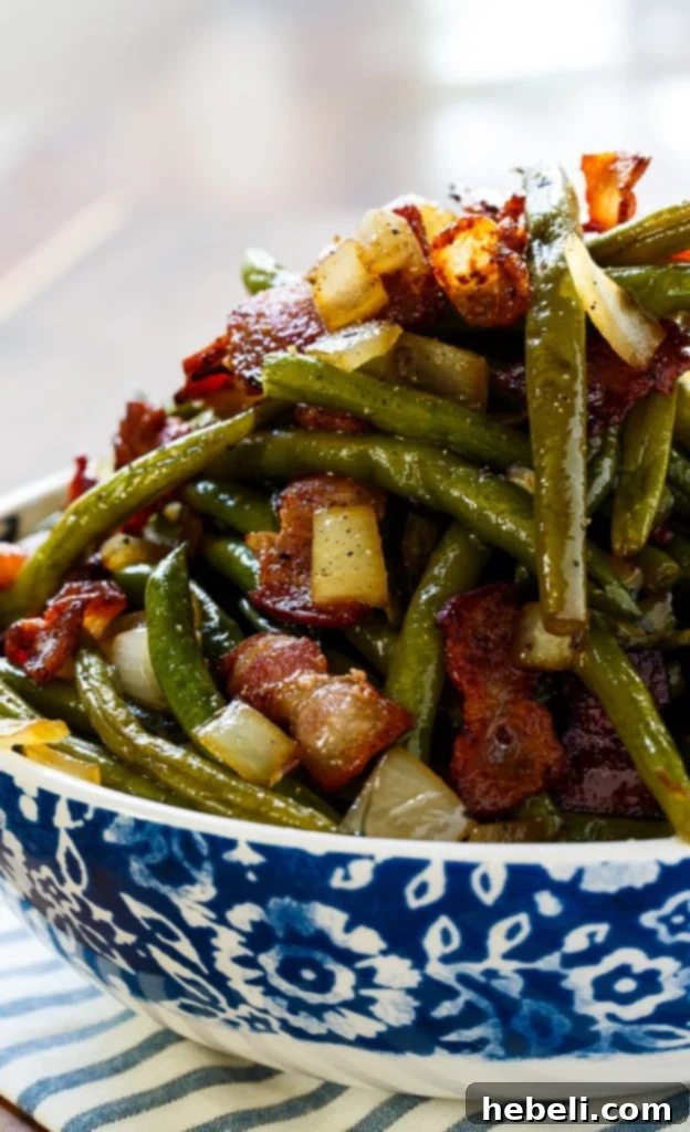 A serving bowl filled with Sweet and Sour Green Beans, garnished with crispy bacon, ready for the table.
