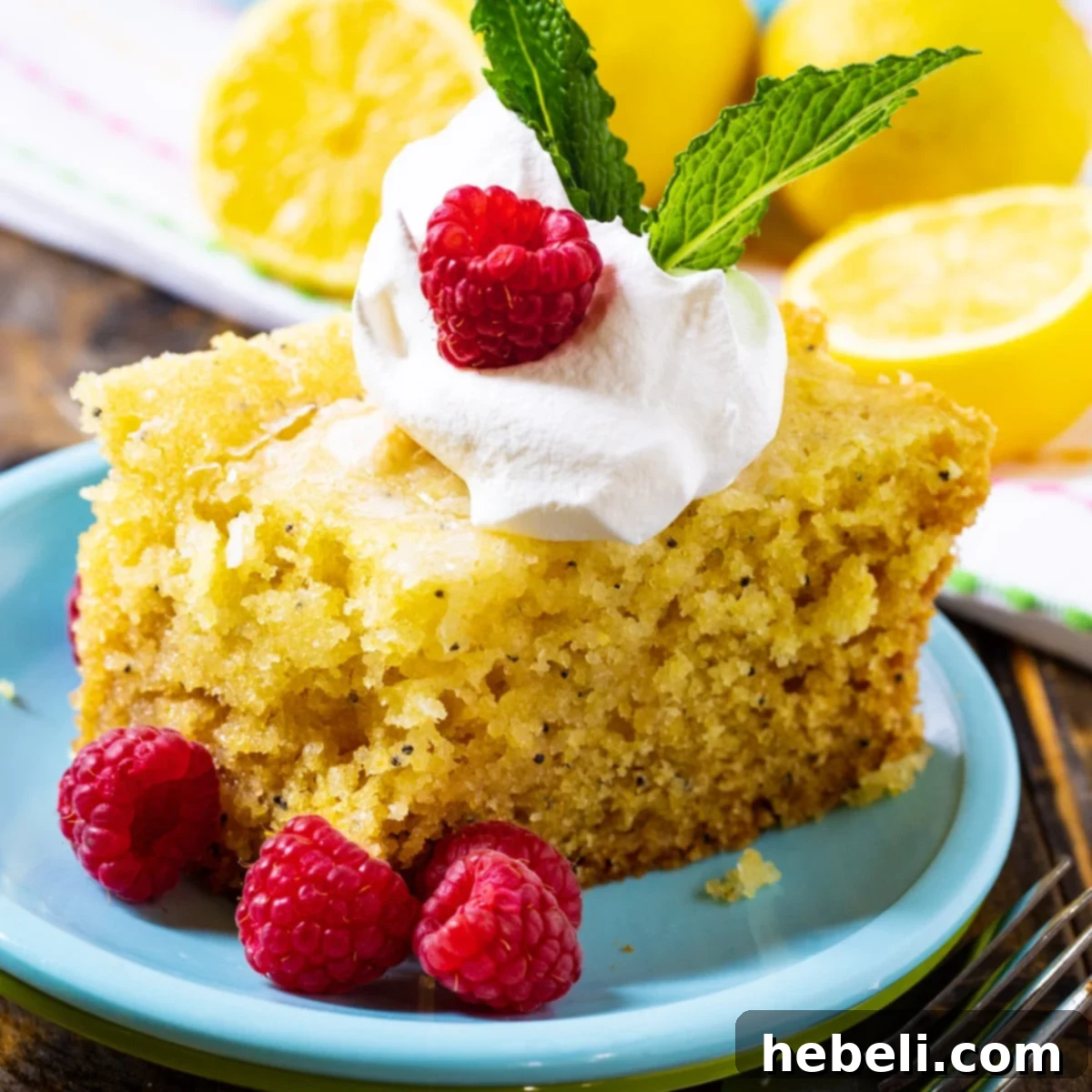 Crock-Pot Lemon Cloud Cake 2 A delectable slice of Slow Cooker Lemon Cake, beautifully garnished with fresh raspberries and a hint of whipped cream.