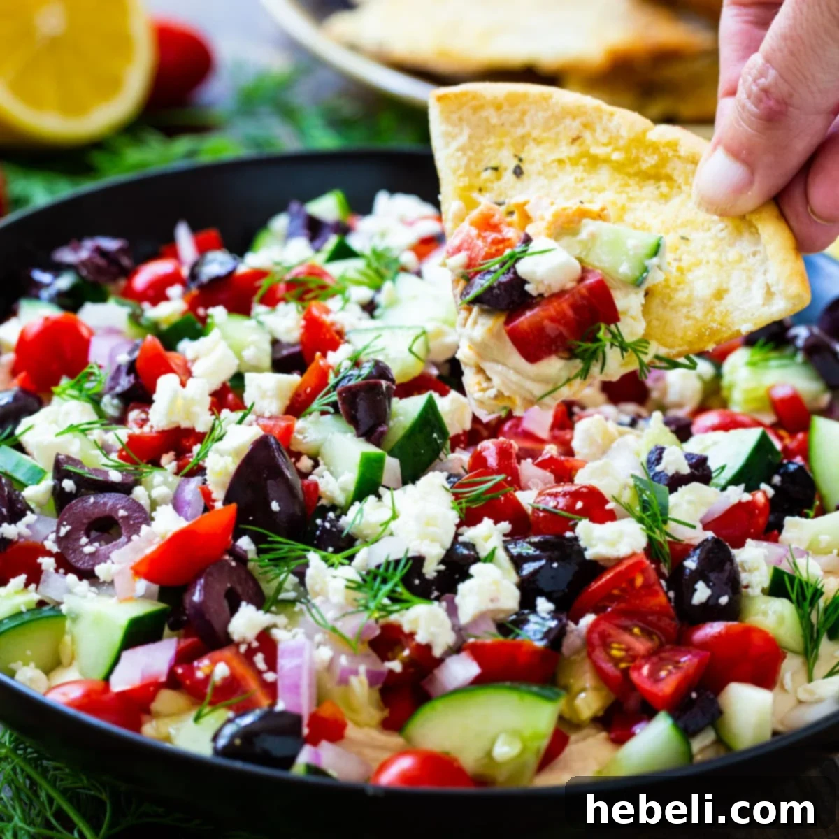 Pita chip scooping up dip.