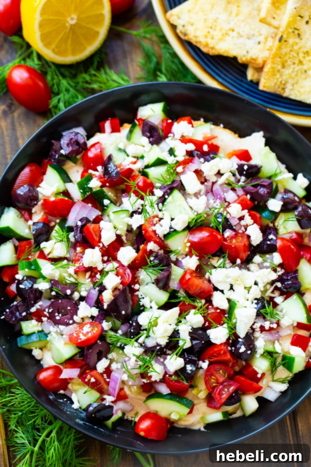 Greek Dip in bowl and pita chips on plate.