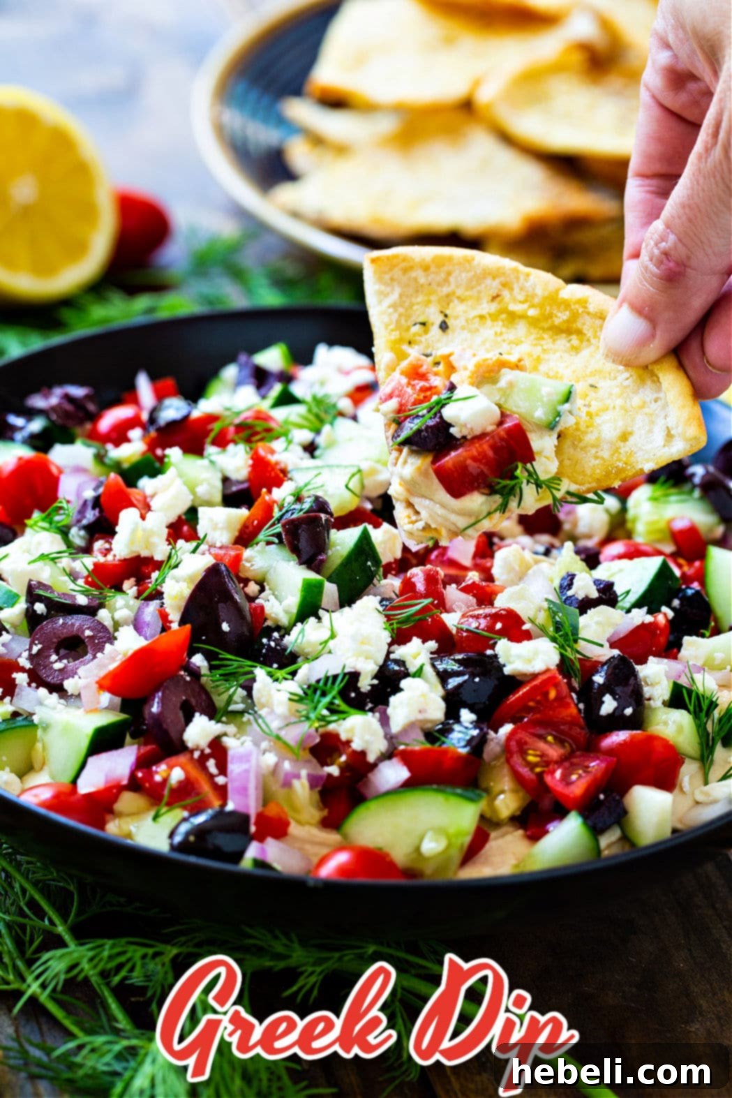 Pita chip scooping up Greek Dip.