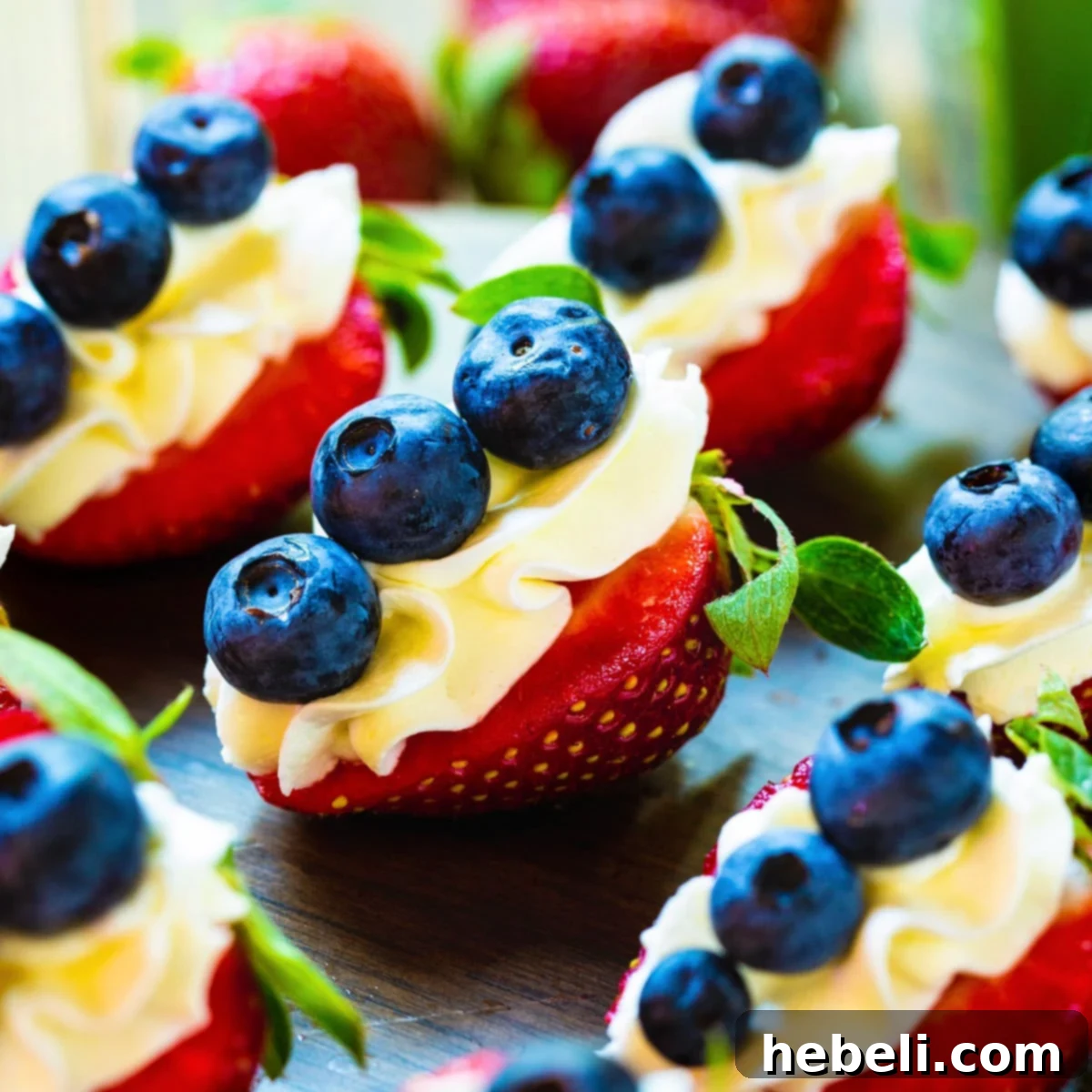 Red, White, and Blue Cheesecake Strawberries arranged beautifully on a dark wooden board, ready for serving.