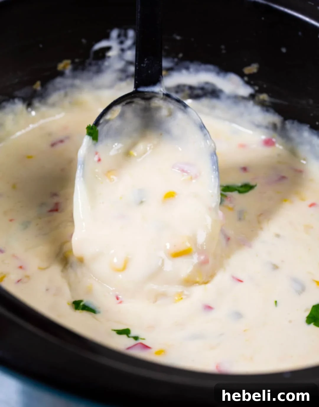 Creamy Crock Pot Queso Blanco 3 Crock Pot Queso Blanco getting scooped up with a spoon.