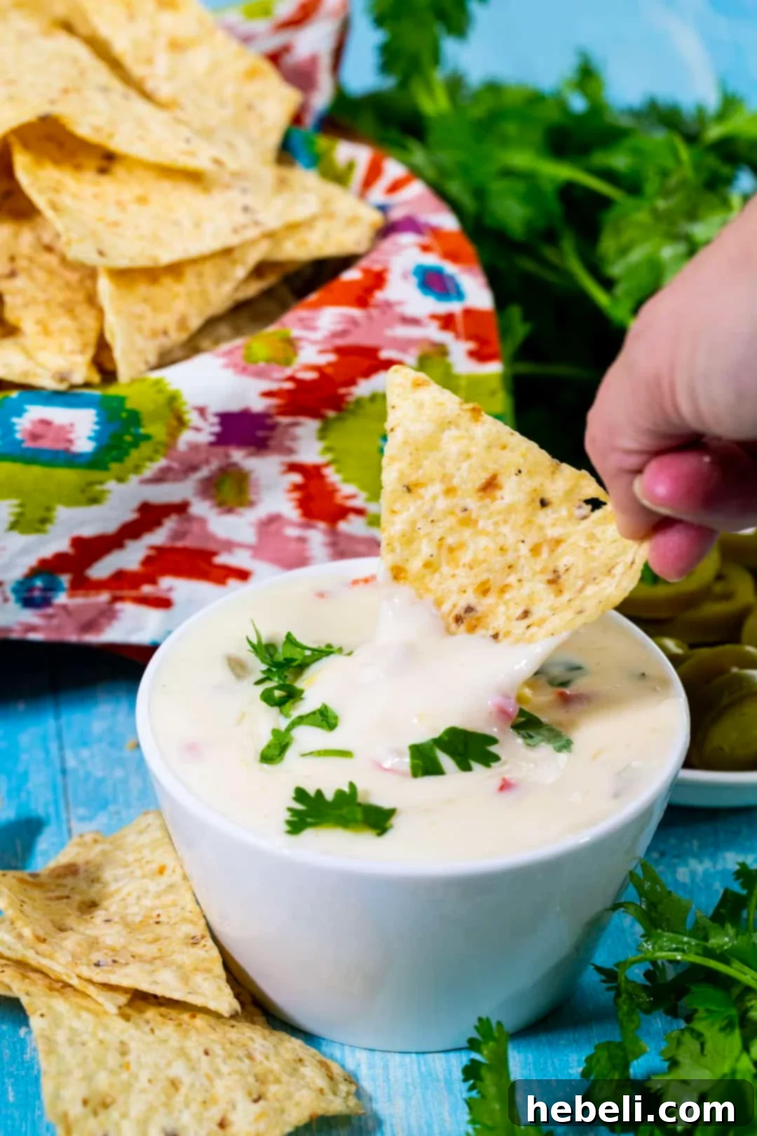 Creamy Crock Pot Queso Blanco 5 Chip dipping into queso.