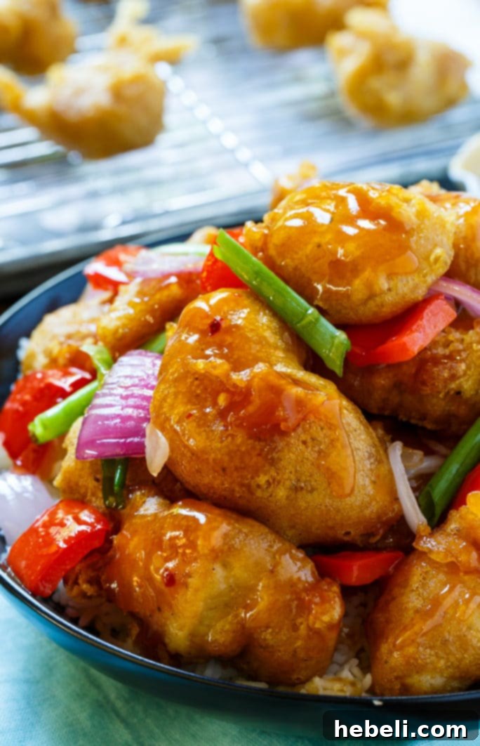 A serving of homemade Sweet and Sour Chicken with colorful bell peppers and onions, ready to be enjoyed.