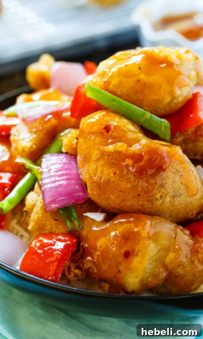 Close-up of the delicious Sweet and Sour Chicken, highlighting its texture and glossy sauce.