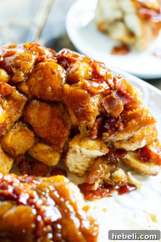 A slice of Bacon Maple Monkey Bread, showing the layers of dough, bacon, and maple glaze.