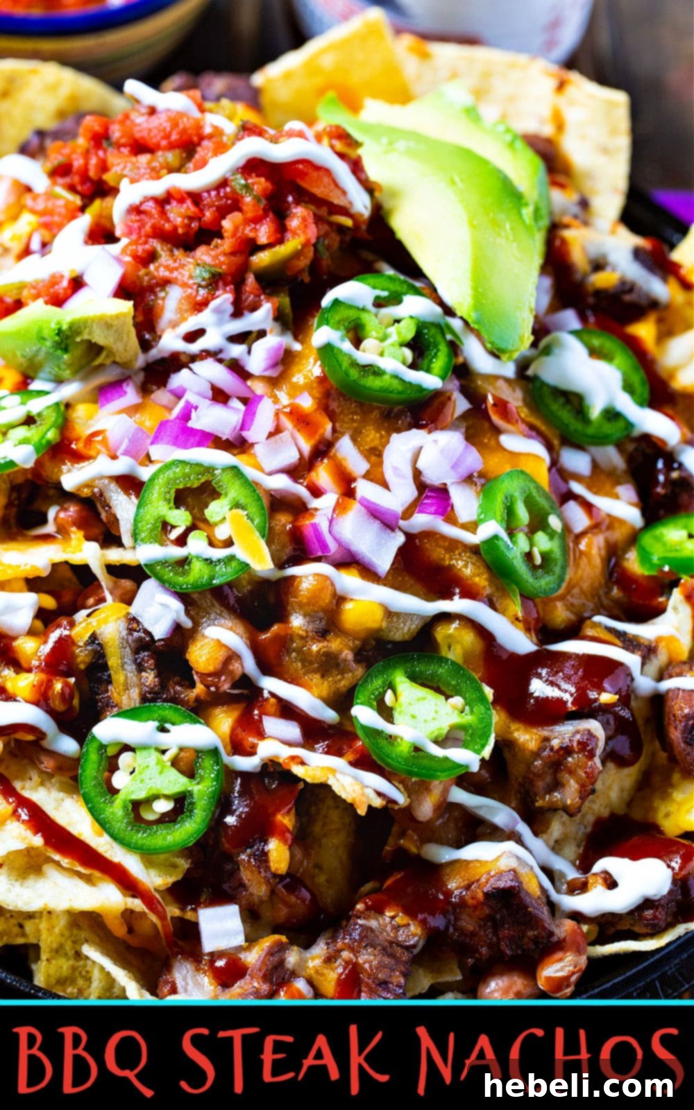 A stunning shot of BBQ Steak Nachos, showcasing the generous toppings of grilled rib-eye, pinto beans, and corn for a mouthwatering appetizer.
