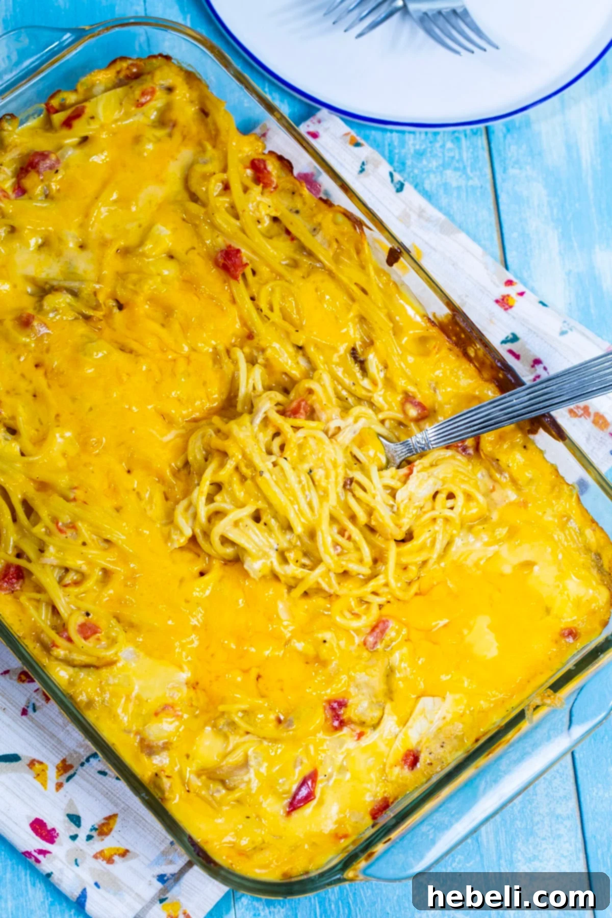 Kickin' Chicken Spaghetti 4 Spicy Chicken Spaghetti casserole in a 9x13-inch baking dish, ready for the oven with a layer of cheese on top.