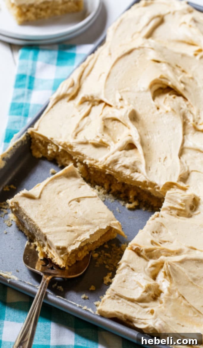 A perfectly frosted Peanut Butter Sheet Cake, ready for serving at a potluck or family gathering. The fluffy peanut butter frosting promises a delightful experience.
