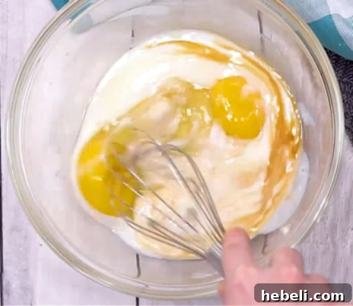Mixing wet ingredients in a bowl with a whisk.