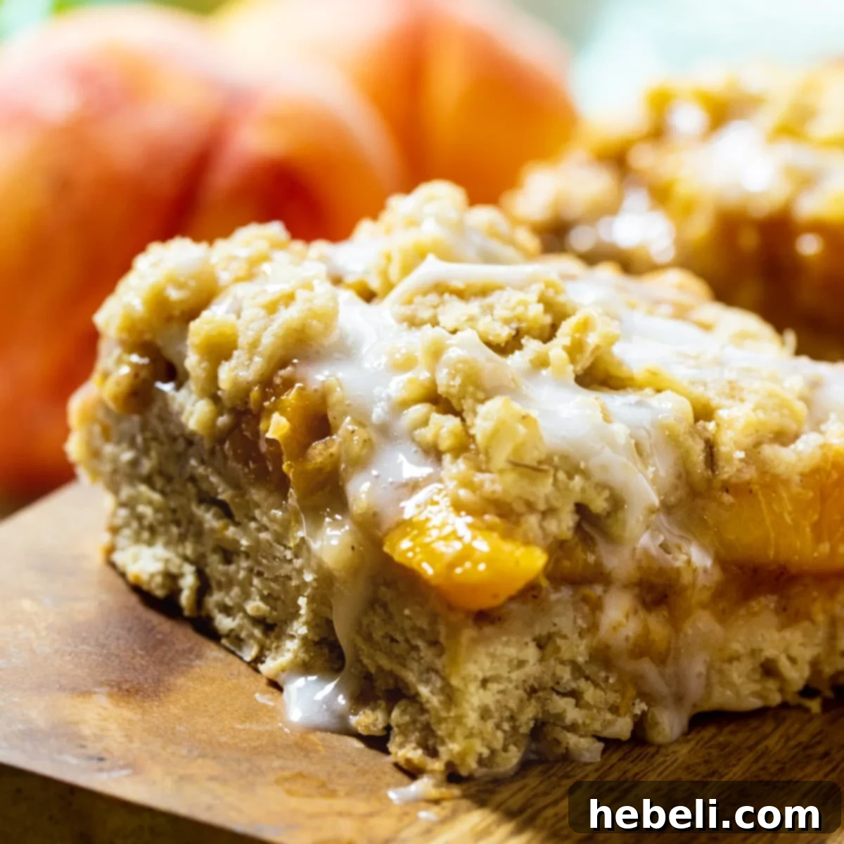 Easy and Delicious Peach Cobbler Bars 2 Delicious Peach Cobbler Bars with fresh peaches in the background, perfect for a summer treat.