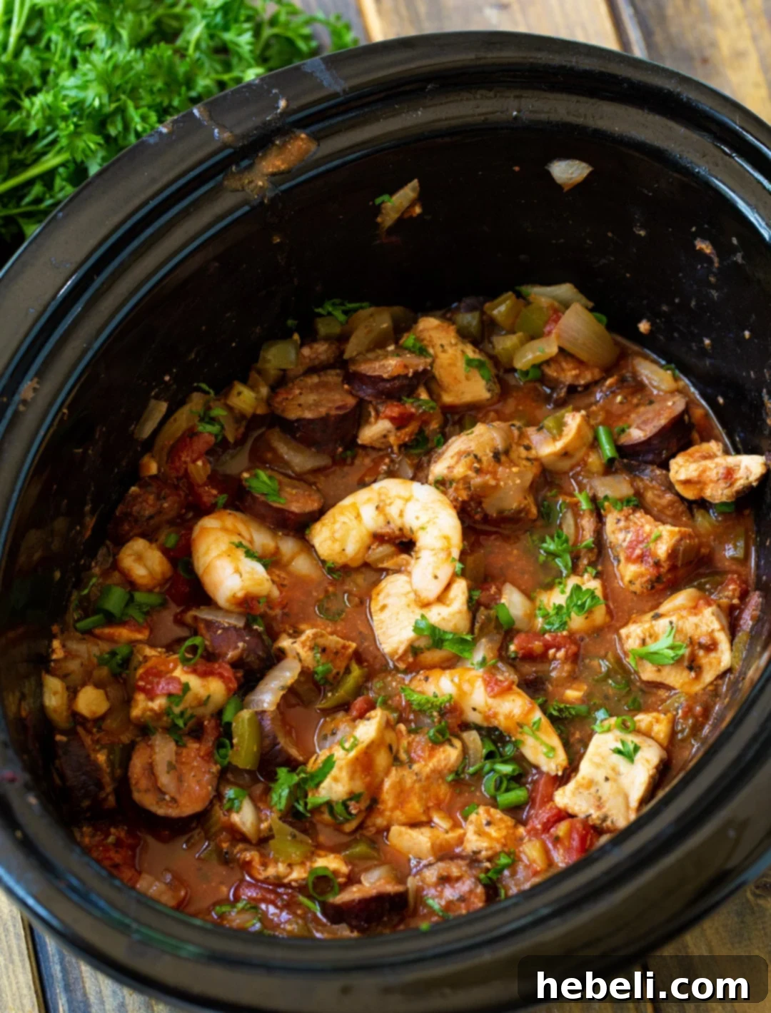 Set-and-Forget Slow Cooker Jambalaya 3 Jambalaya simmering in a slow cooker, showcasing the rich colors of the ingredients.