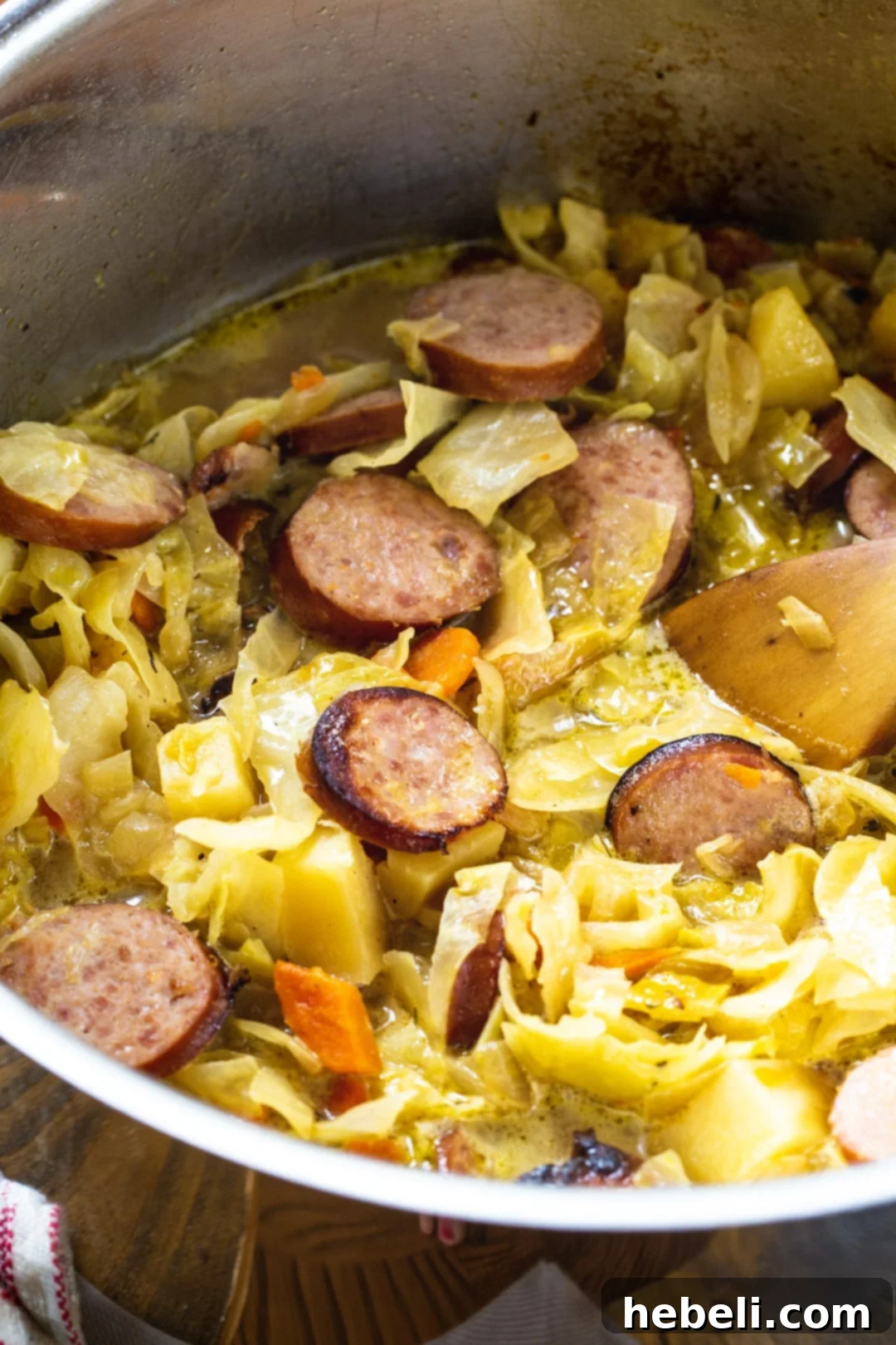 Close-up view of Cabbage Soup with Smoked Sausage in a pot, showcasing its rich texture with visible sausage, cabbage, and potatoes.