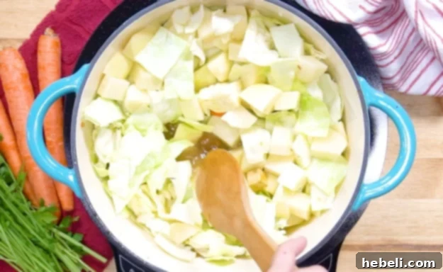 Diced potatoes, chicken broth, water, bouillon, and brown sugar added to the pot with vegetables.