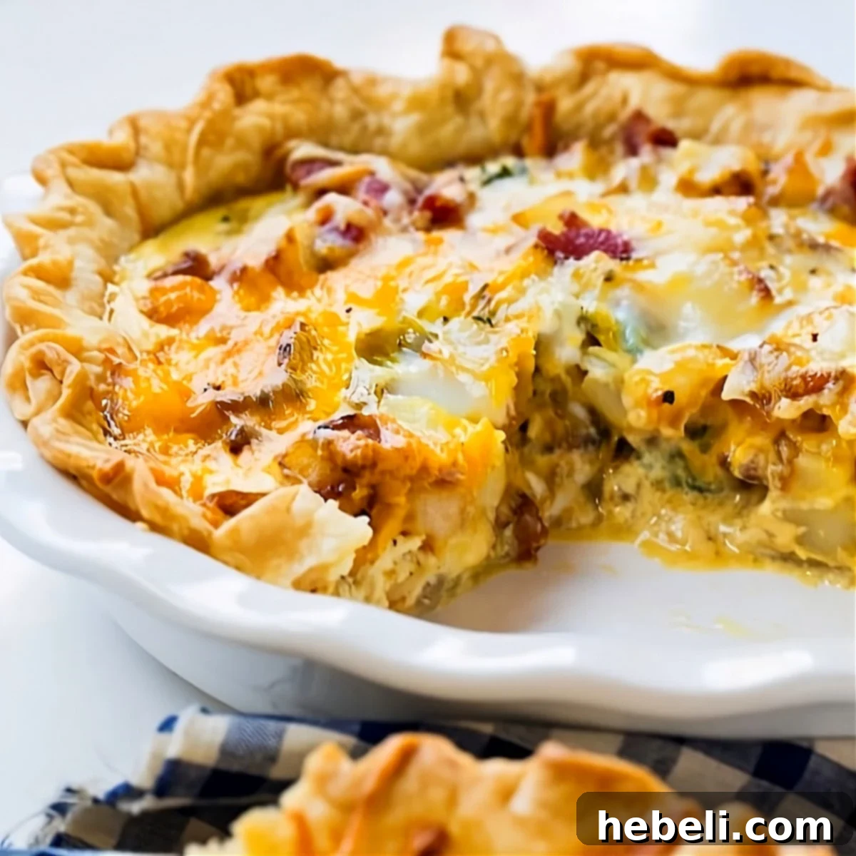Farmhouse Bacon Potato Quiche 2 A slice of delicious Bacon and Potato Quiche with a golden crust and visible filling.