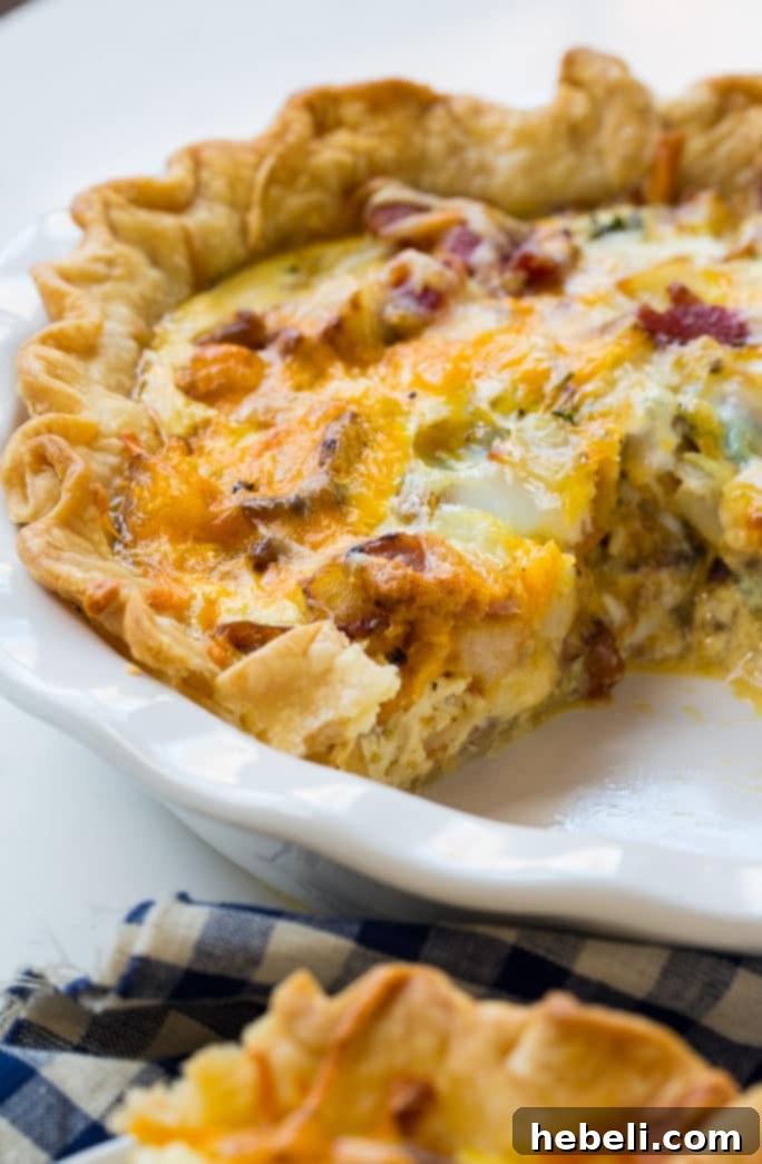 Farmhouse Bacon Potato Quiche 13 A close-up of a fresh slice of Bacon and Potato Quiche, showcasing its hearty layers.