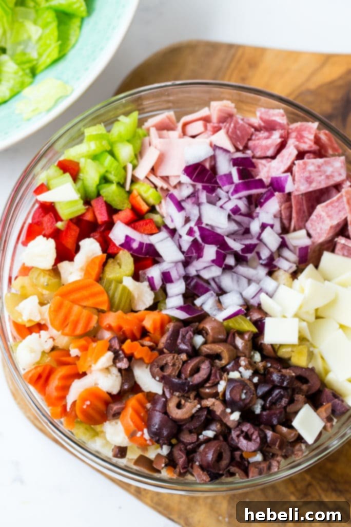 Zesty Italian Deli Salad 3 Close-up of a Muffaletta Salad, showcasing chopped ingredients like meats, cheeses, and colorful vegetables.