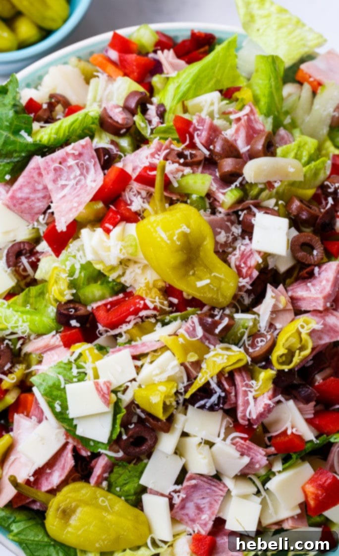 Zesty Italian Deli Salad 5 A serving of Muffaletta Salad featuring an abundance of meat, cheese, and olives, highlighting its rich and satisfying composition.