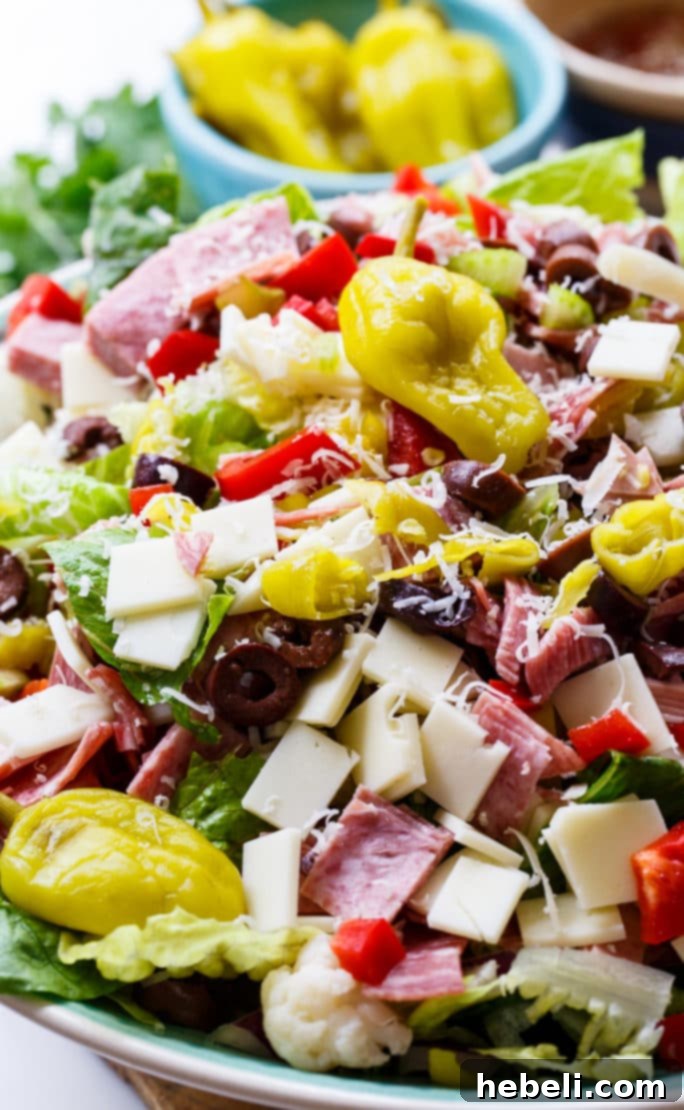 Zesty Italian Deli Salad 6 A large bowl of Muffaletta Salad brimming with chopped meats, cheeses, and olives, emphasizing its completeness as a meal.