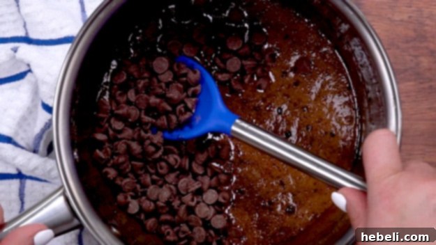 Chocolate chips being folded into the brownie batter.
