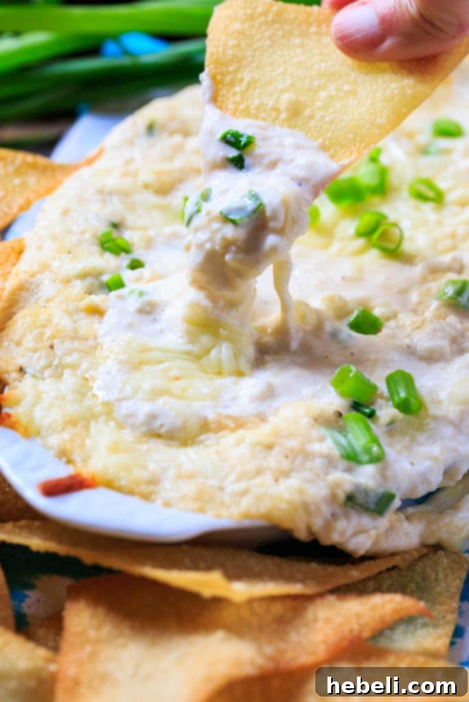 Ultimate Crab Rangoon Dip 6 Crab Rangoon Dip generously garnished with vibrant green onions and artfully surrounded by a heap of golden, crispy wonton chips