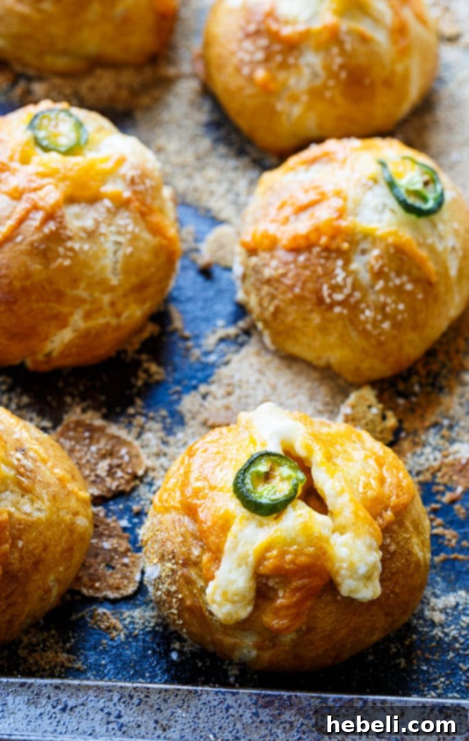 Close-up of a single Jalapeno Popper Stuffed Pretzel Roll with a perfectly golden crust, showcasing its texture