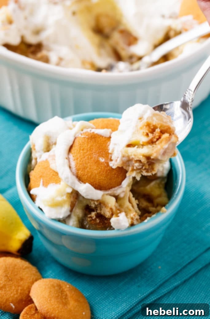 Layers of Bananas Foster Banana Pudding in a glass dish, showing the creamy custard, bananas, and wafers.