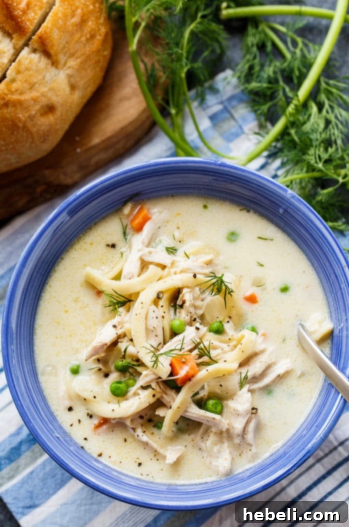 Comforting Chicken Noodle Soup 4 Rich and creamy chicken noodle soup simmering in a Dutch oven