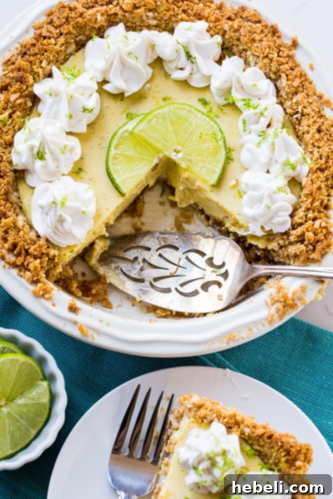 Slice of creamy lime pie topped with coconut whipped cream