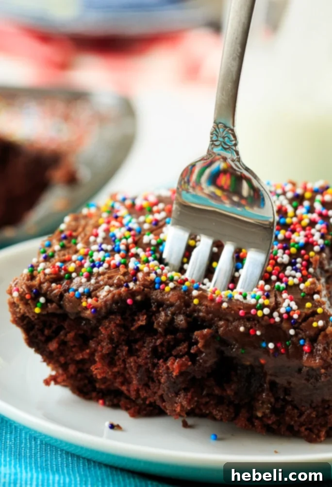 A slice of Chocolate Wacky Cake with icing and sprinkles