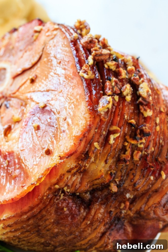 Praline Glazed Ham sliced on a serving platter, showcasing the rich glaze and tender meat